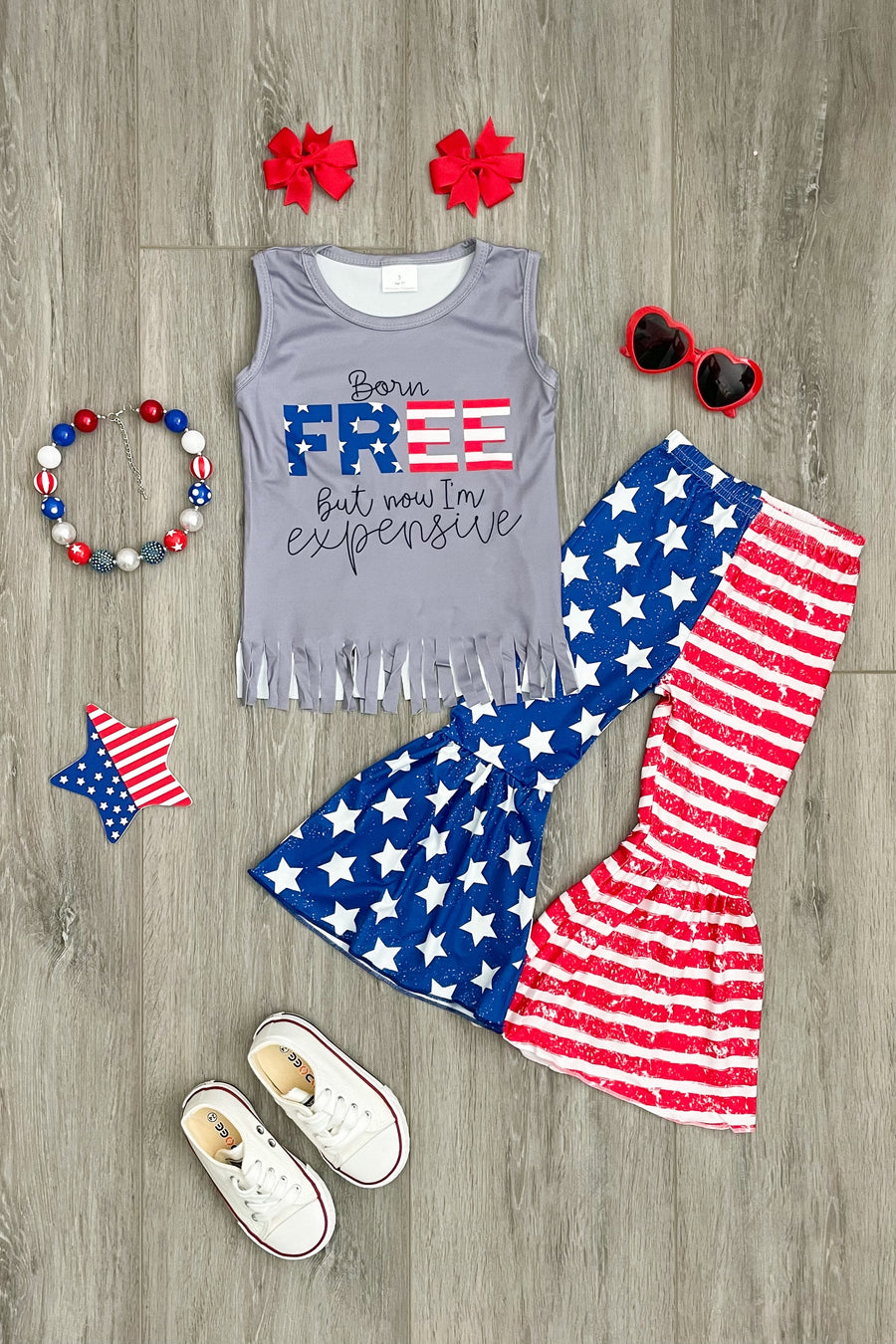RUN! How precious is this bells set? "Born FREE, but now I'm expensive" - it's absolutely a must-have! We do expect this one to sell fast so don't wait if you must have it!  •Sizing: generous. •Includes top & pants only. •Accessories sold separately! •Accessories pictured: red pinwheel bows, USA necklace, red heart eye sunnies •Material: poly blend. •Imported.